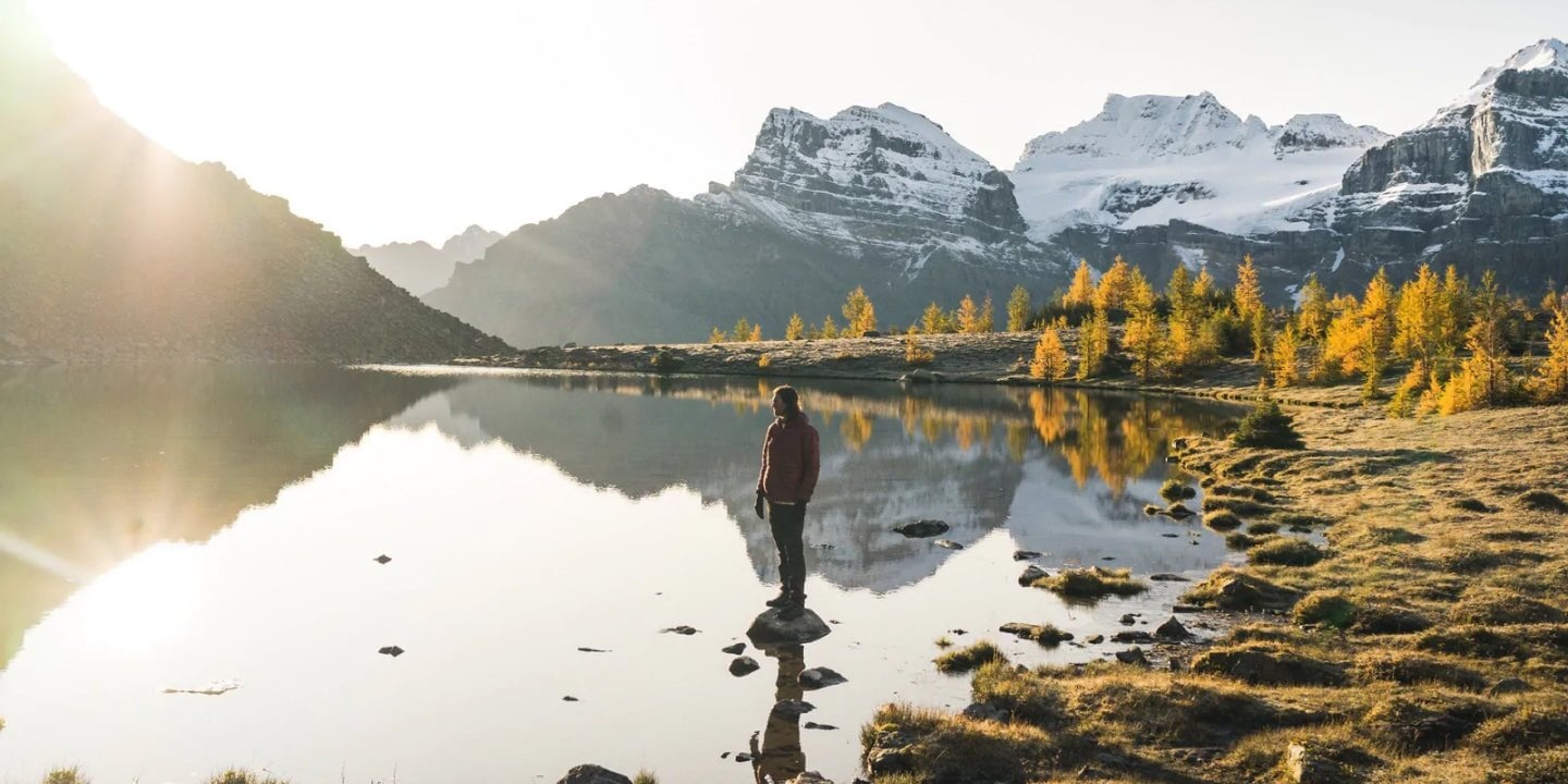 hiker standing on a rock in a lake