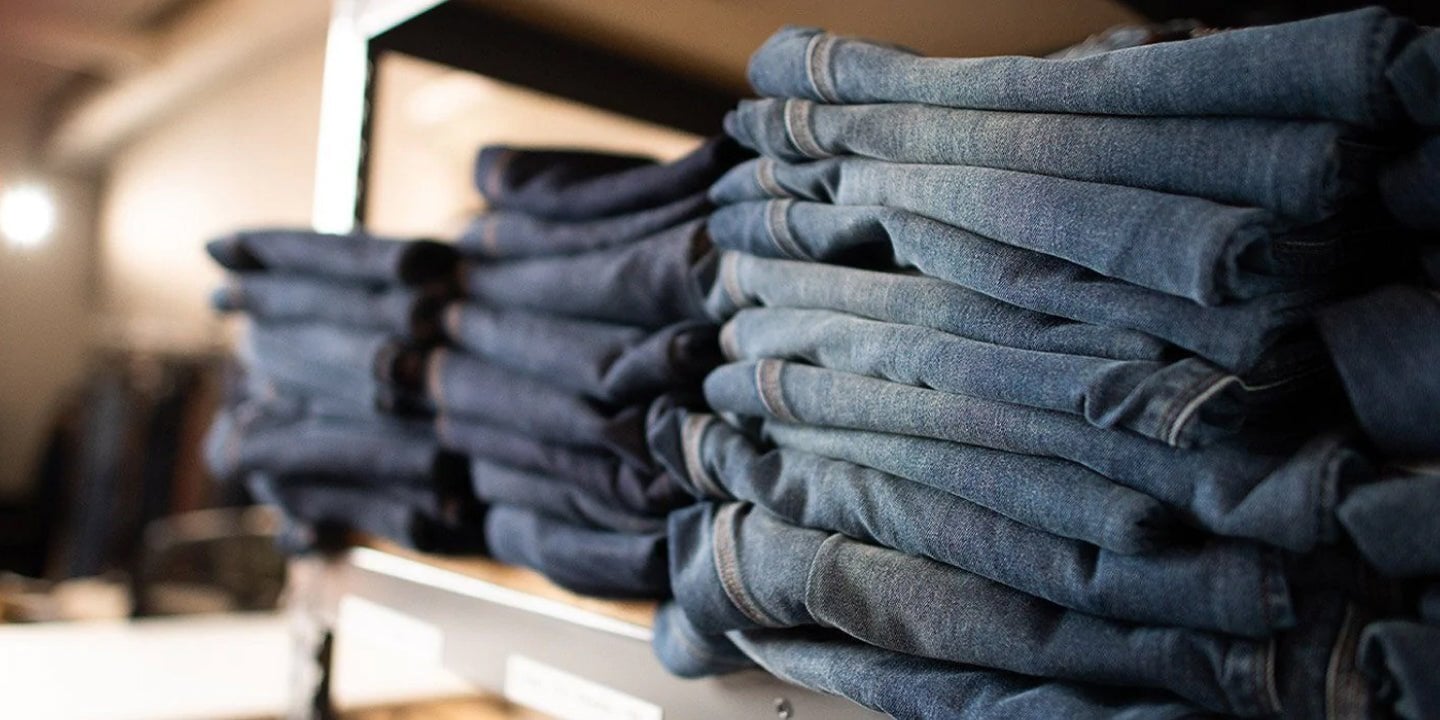 Multiple pairs of denim jeans stacked on a shelf