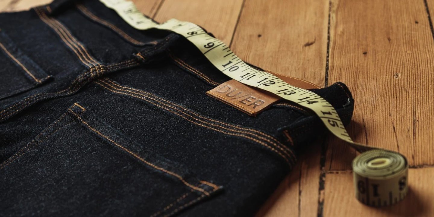A pair of jeans being measured at the waist