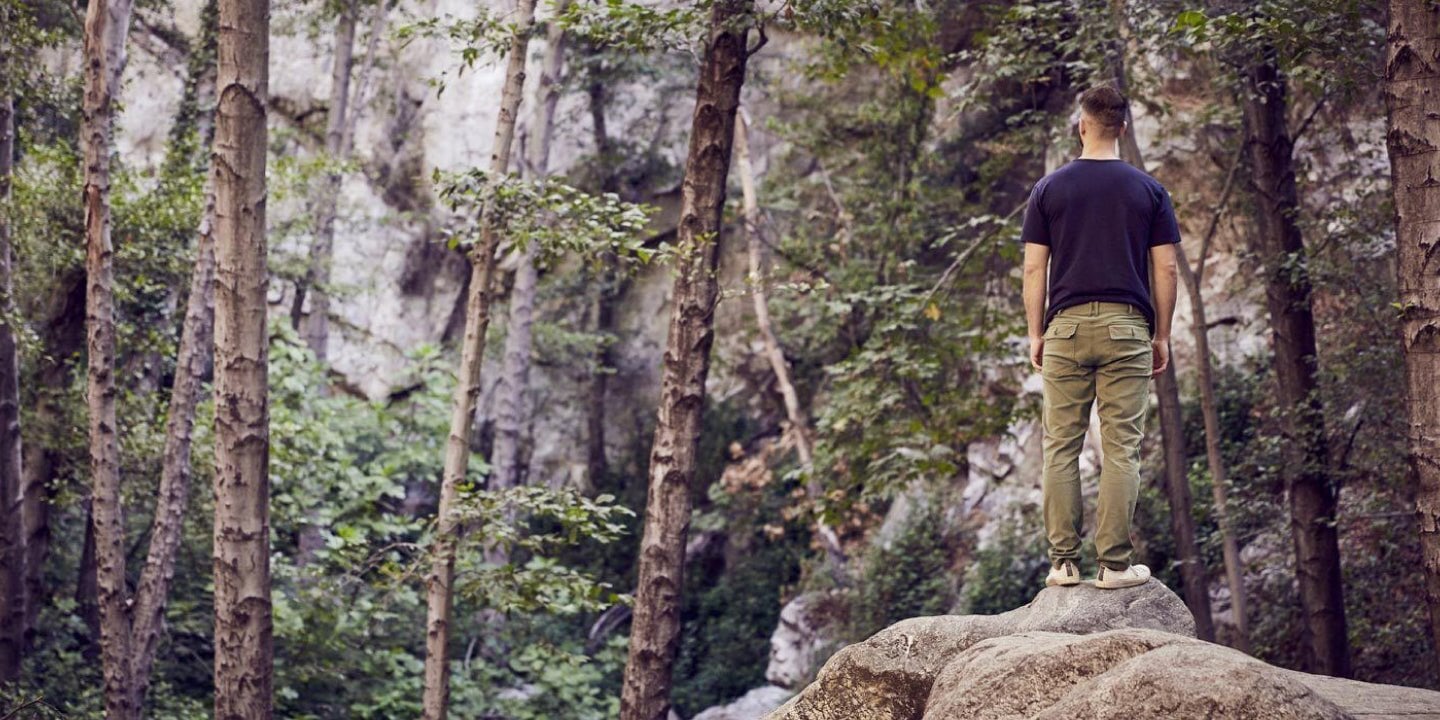 Man on a rock wearing DUER pants