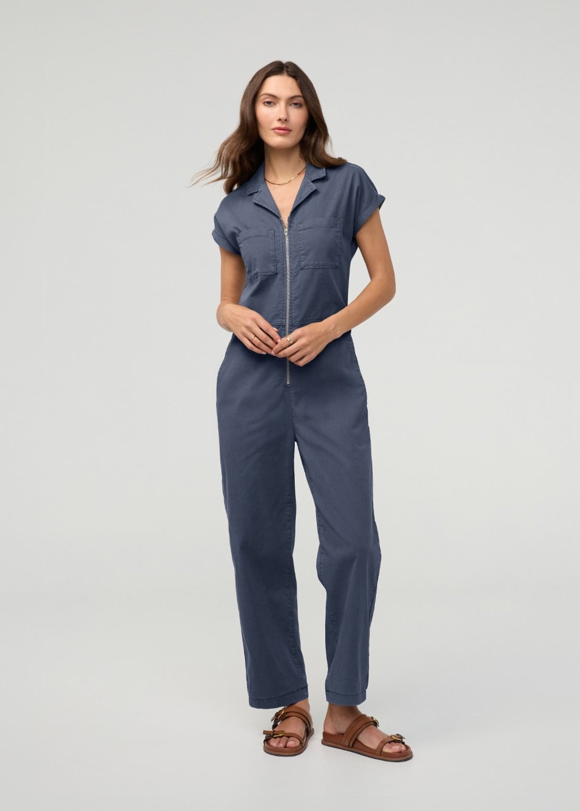 Blue boiler suit with short sleeves, front zip closure, and straight-leg pants worn by a woman.