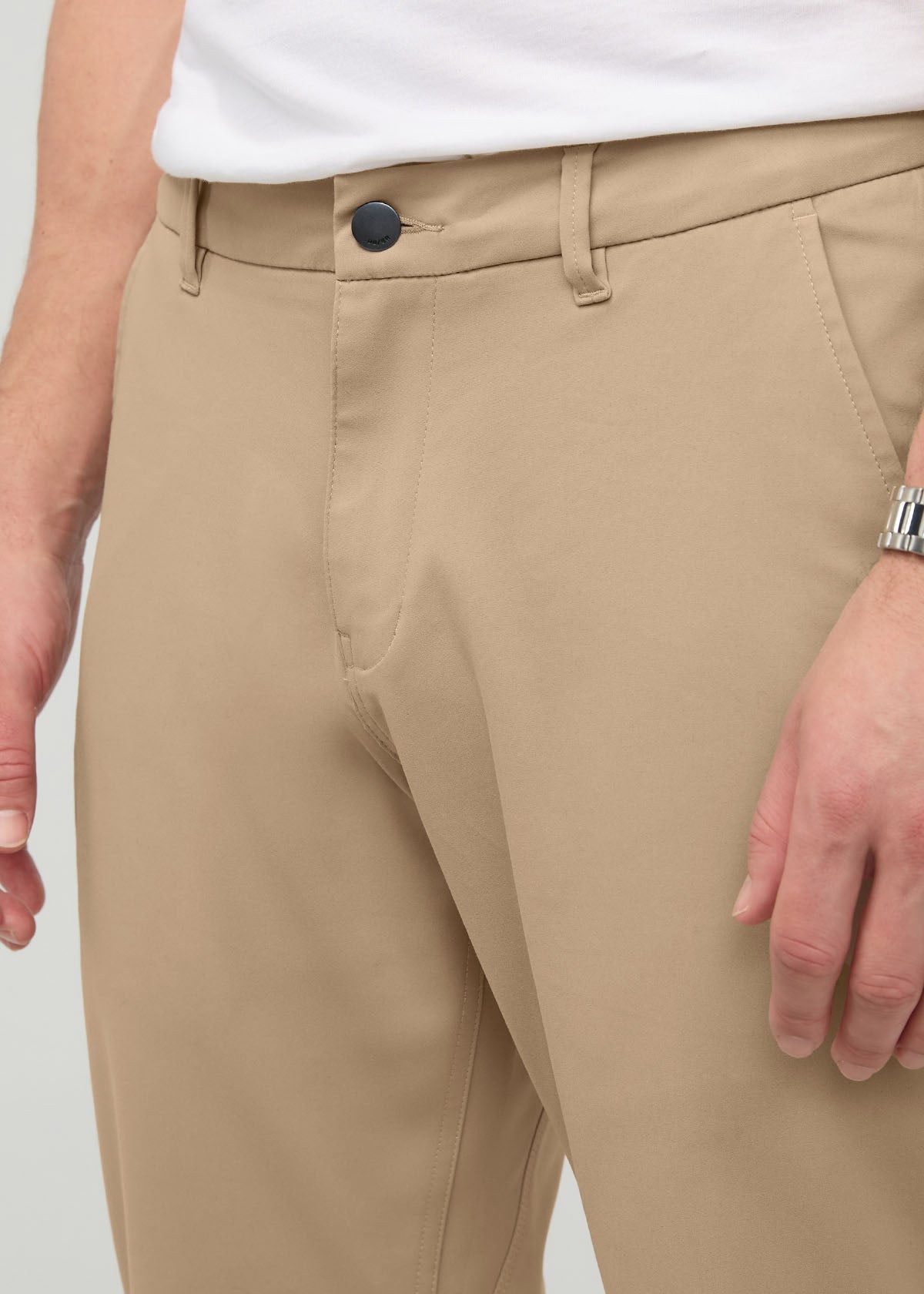 Desert khaki relaxed taper trousers with button closure and belt loops, worn with white shirt.