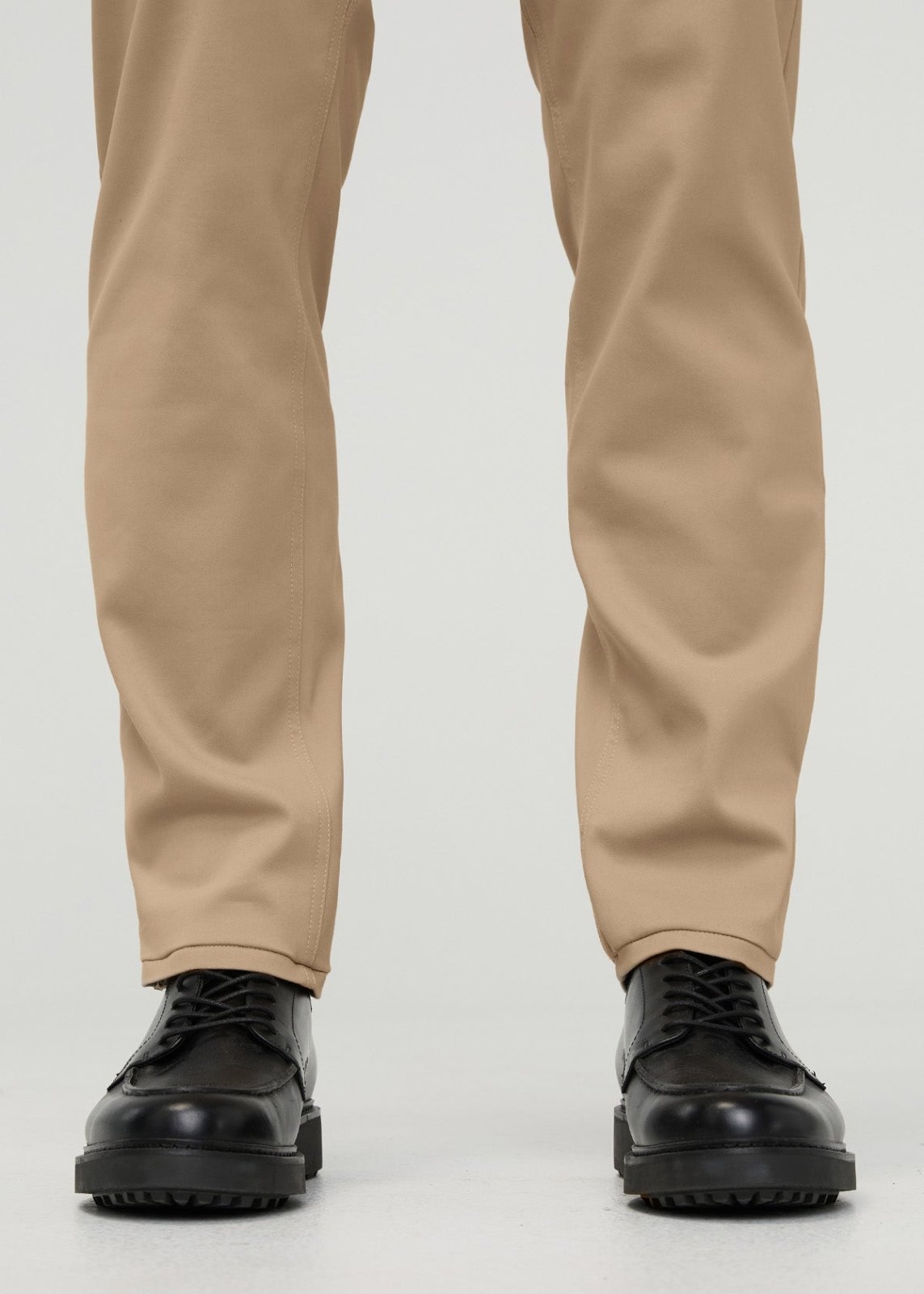 Khaki relaxed taper trousers with tapered ankles, shown paired with black lace-up oxford shoes.