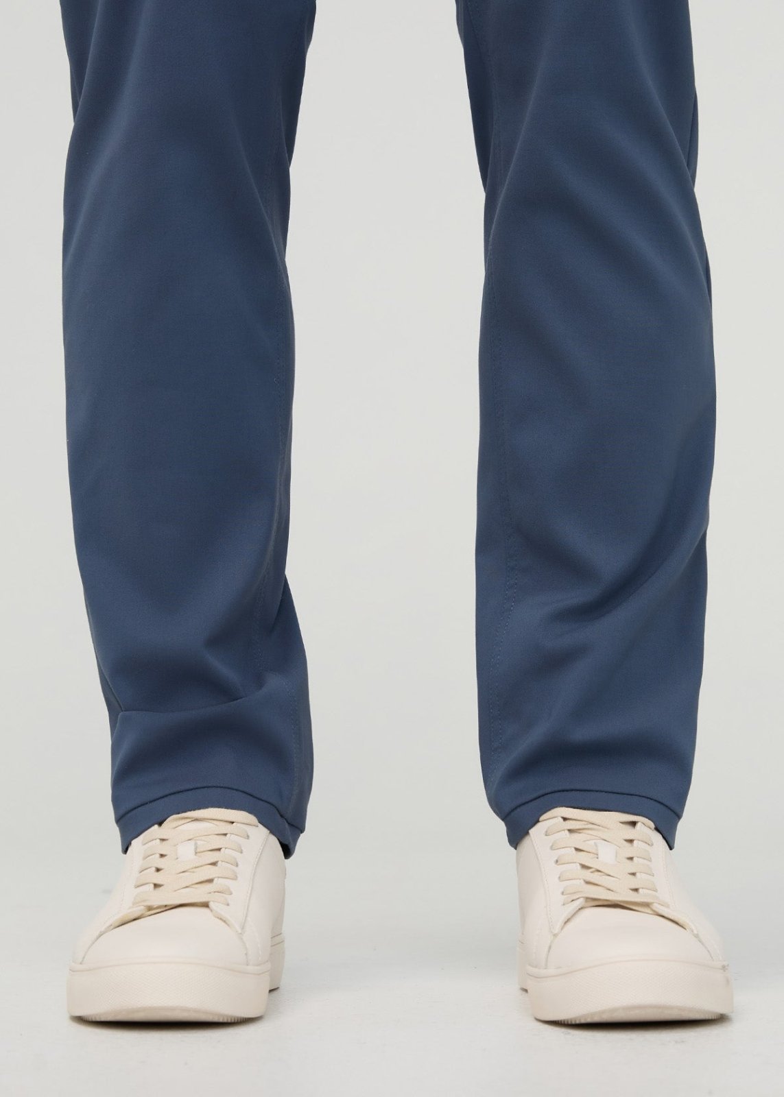 Dark blue relaxed taper trousers with tapered ankles, shown with cream platform sneakers.