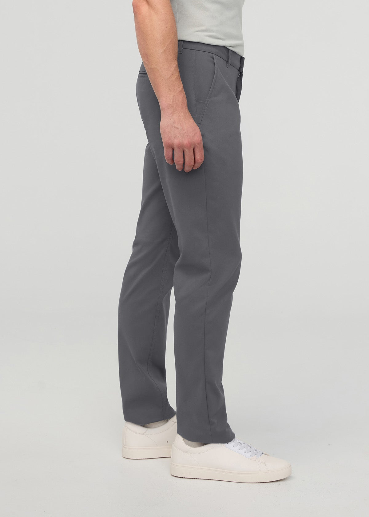 Dark gray relaxed taper trouser with tapered ankle on model wearing white sneakers.