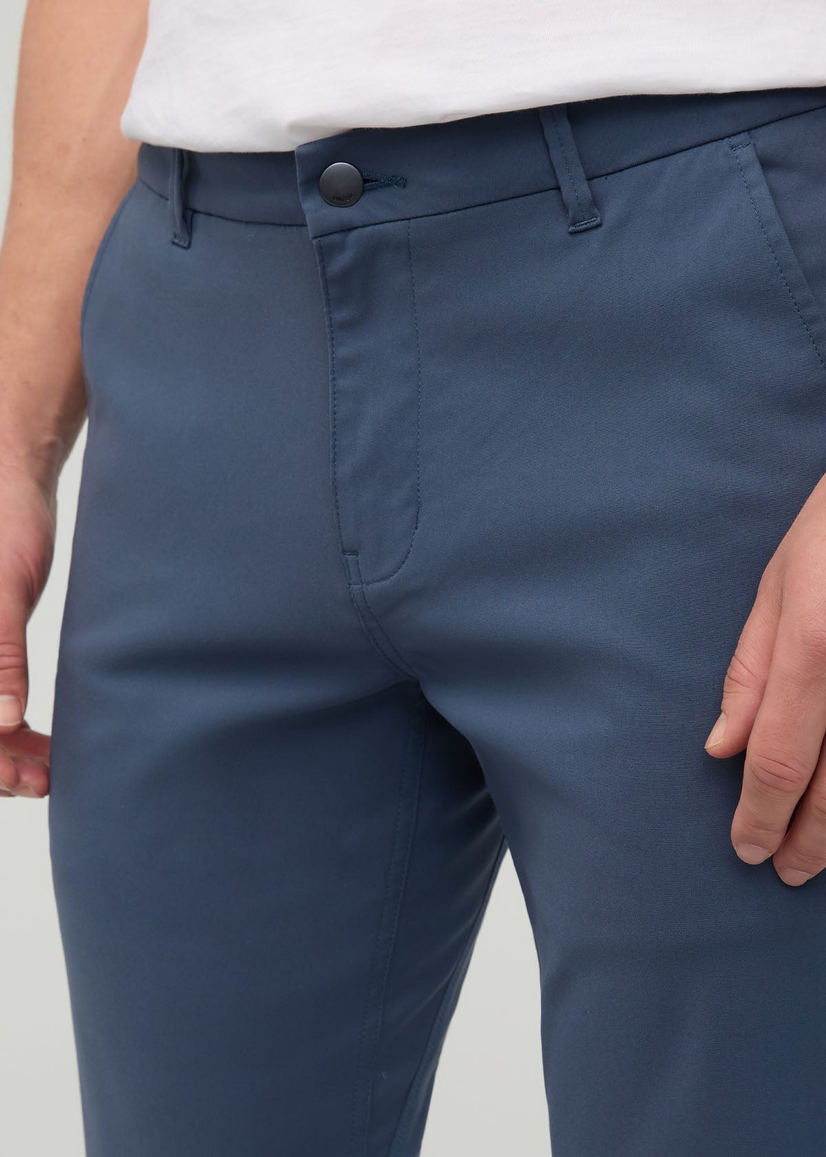 Heritage blue slim straight trousers with button closure and belt loops, worn with white shirt.
