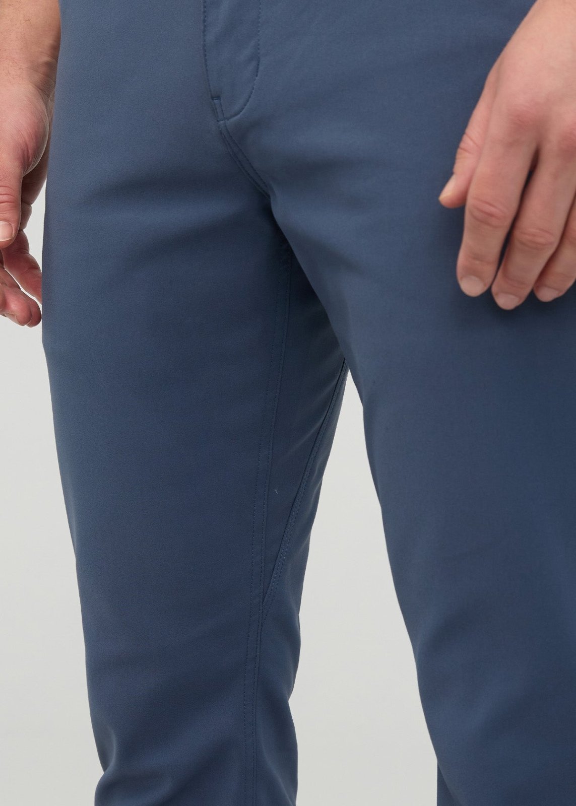 Blue slim straight trousers with visible seam detail on the legs, worn by a model showing the fit from waist to knee.