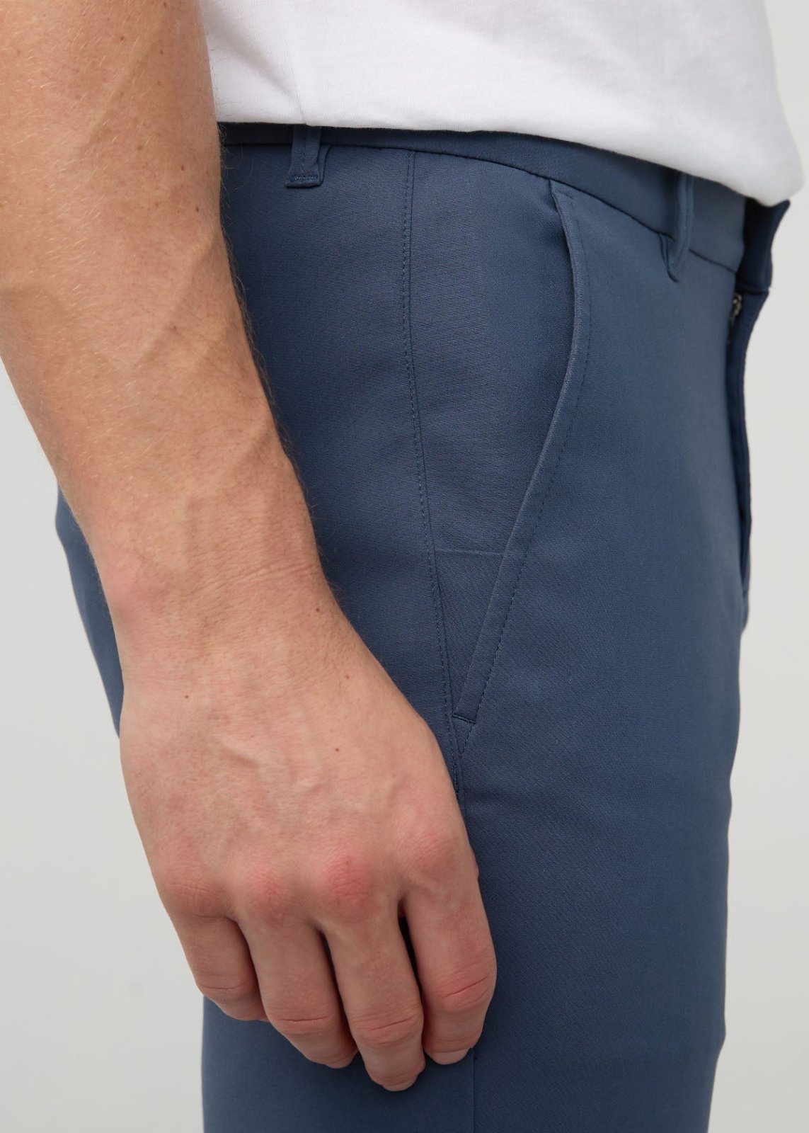 Navy blue slim straight trousers with flat front waistband and side pockets, worn with white shirt.