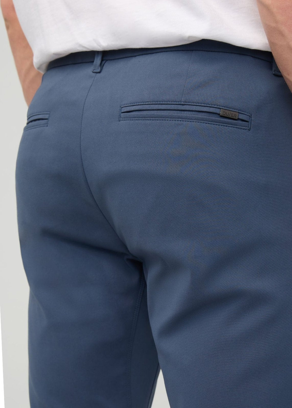 Heritage blue slim straight trousers with back pocket detail, worn with white shirt.
