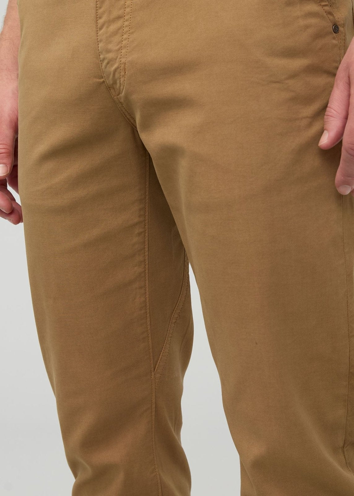 Camel-colored pants with center seam detail, shown on model with hands at sides.