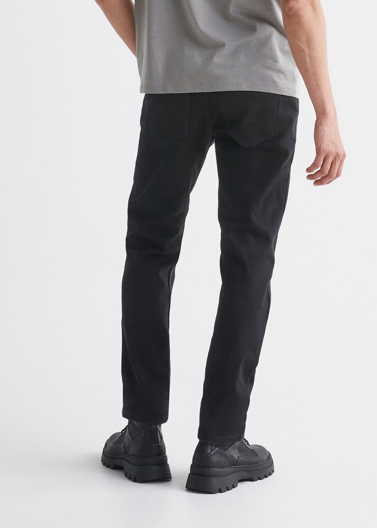 man wearing black slim fit waterproof stretch jeans back