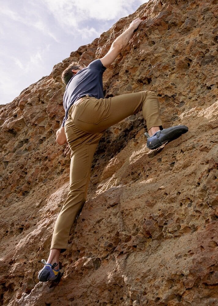 man rock climbing in mustard relaxed fit dress sweatpant